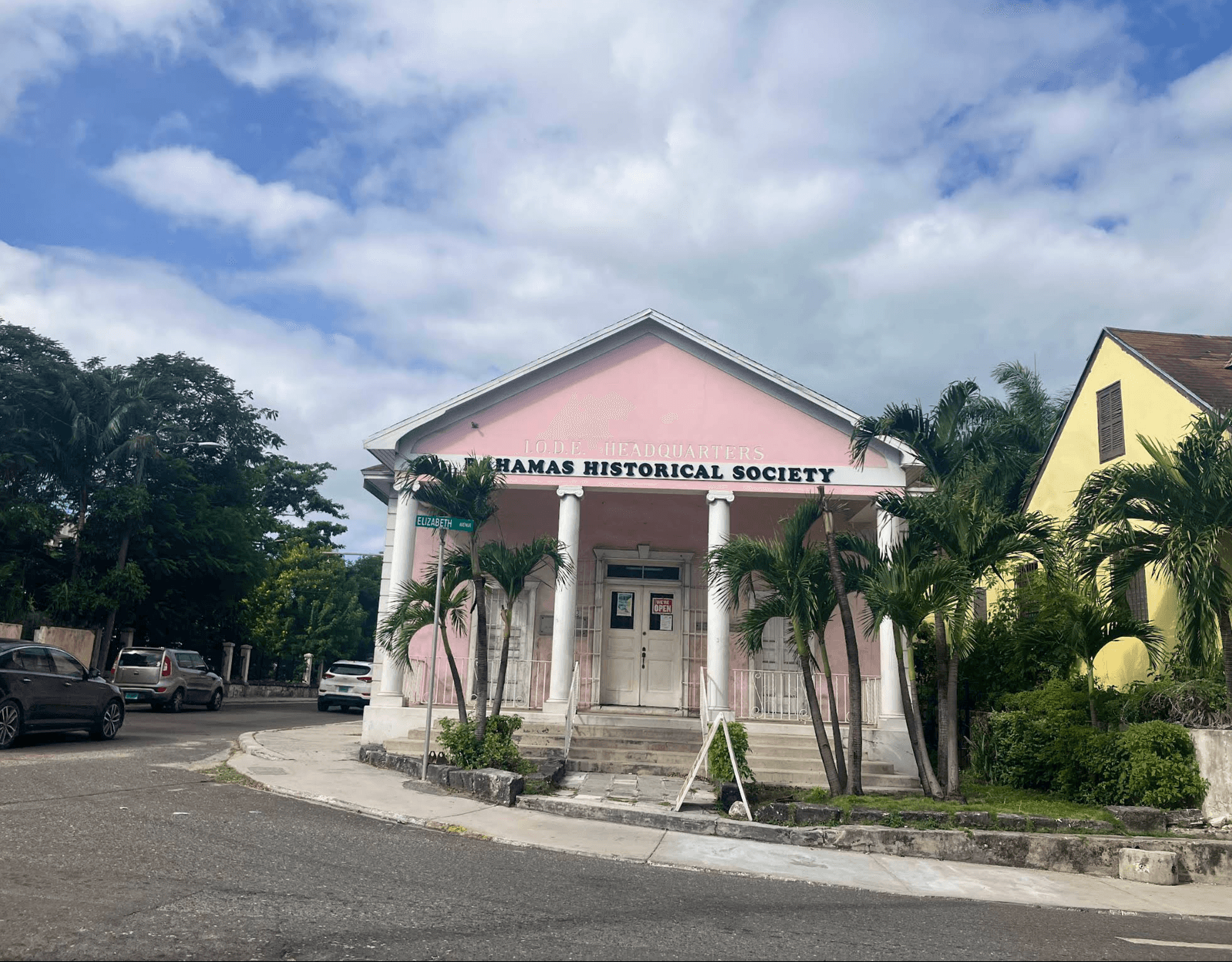 Pink Bahamas Historical Society Museum building with white columns and palm trees