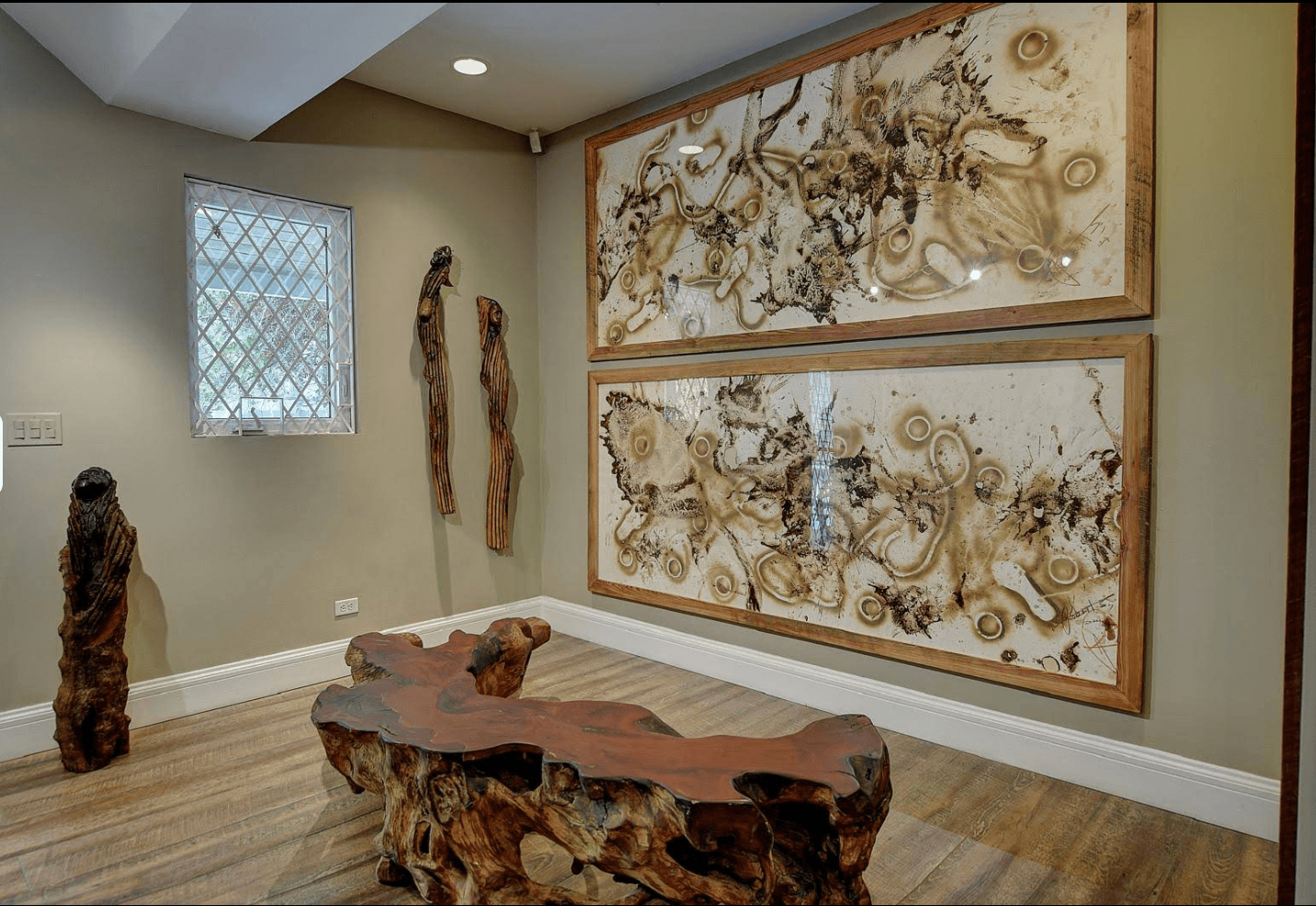 Paintings and wooden sculptures inside V&M Gallery at the D’Aguilar Art Foundation