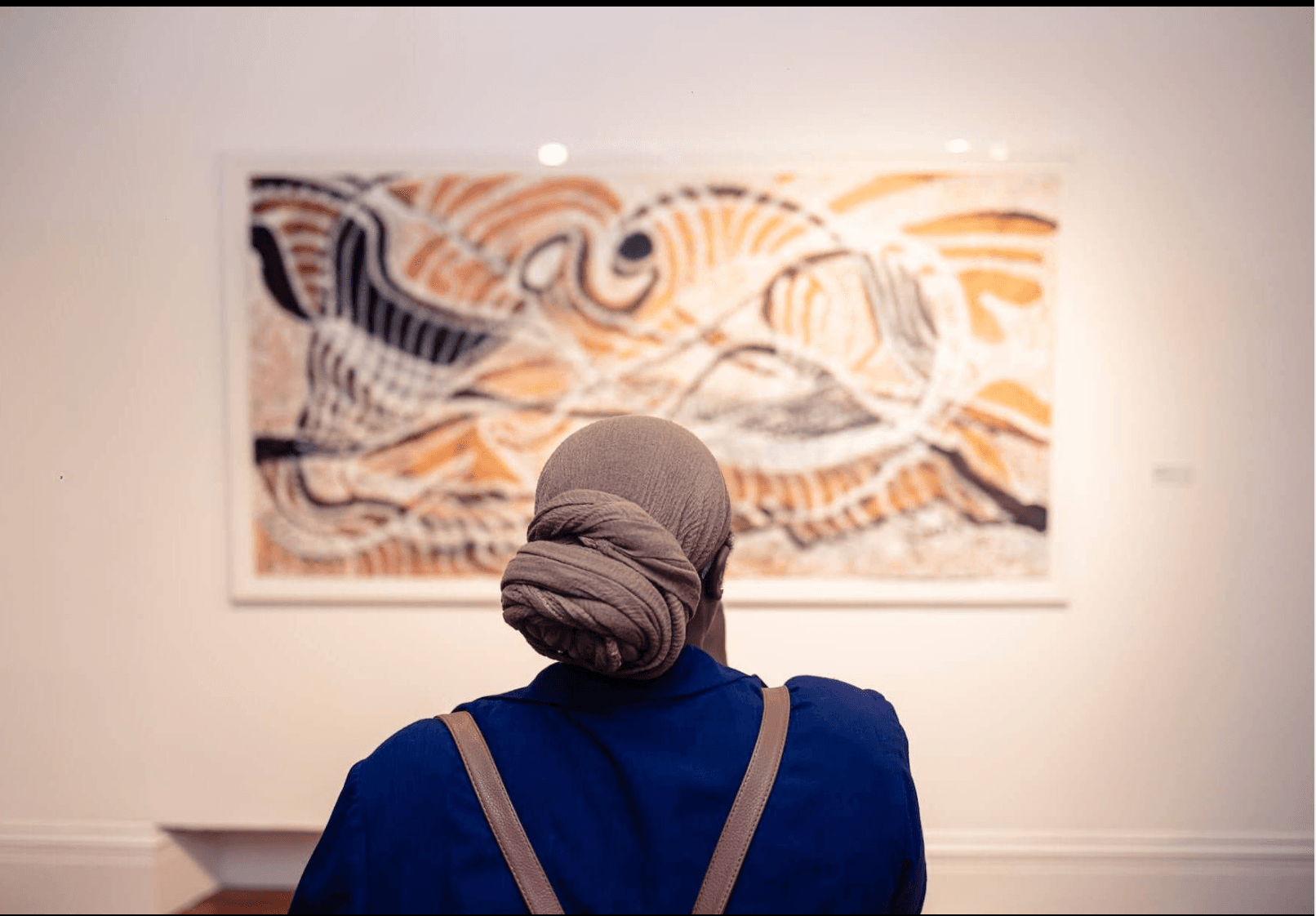 A visitor viewing a painting at the National Art Gallery of The Bahamas