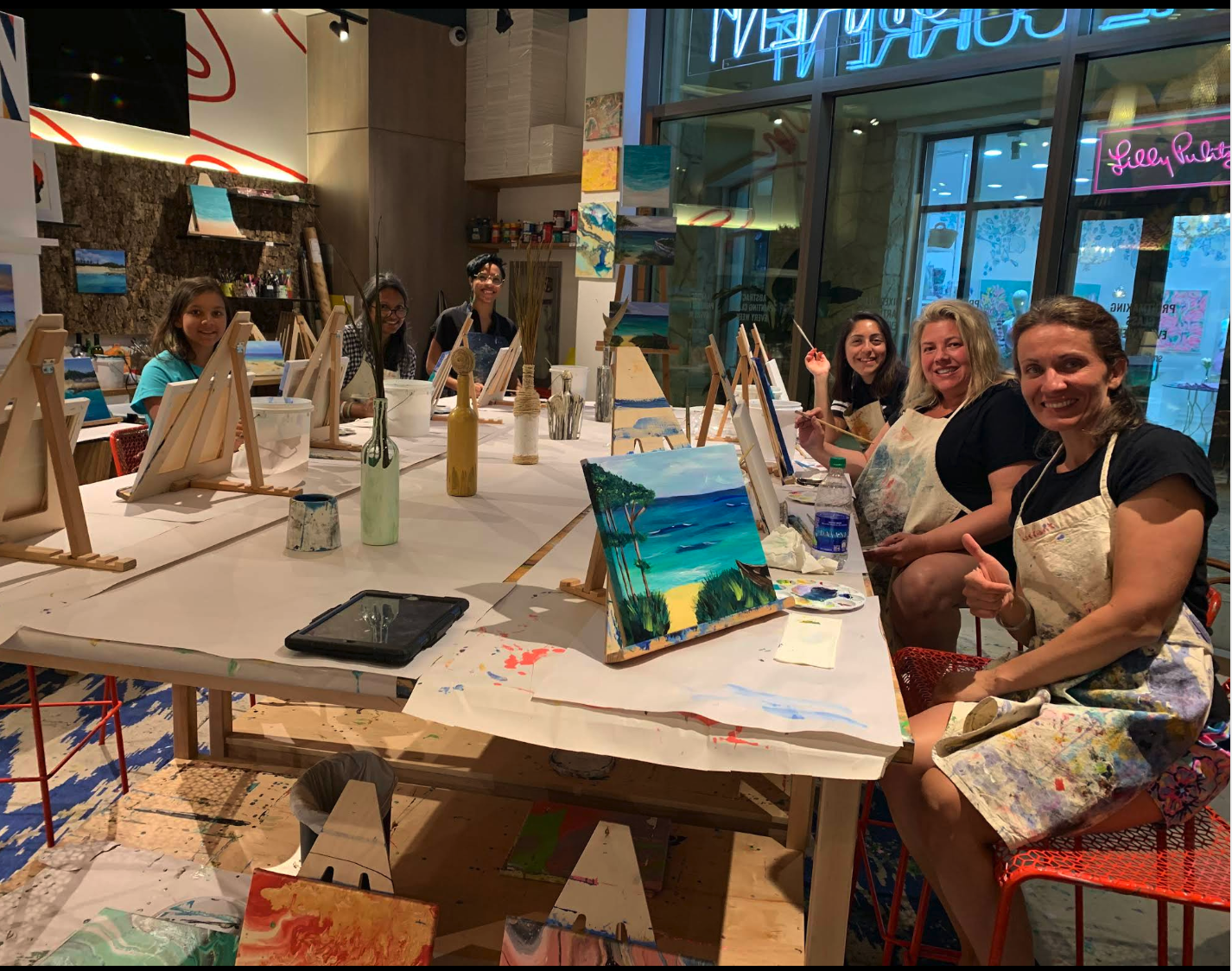 Visitors painting at easels during an art class at The Current at Baha Mar