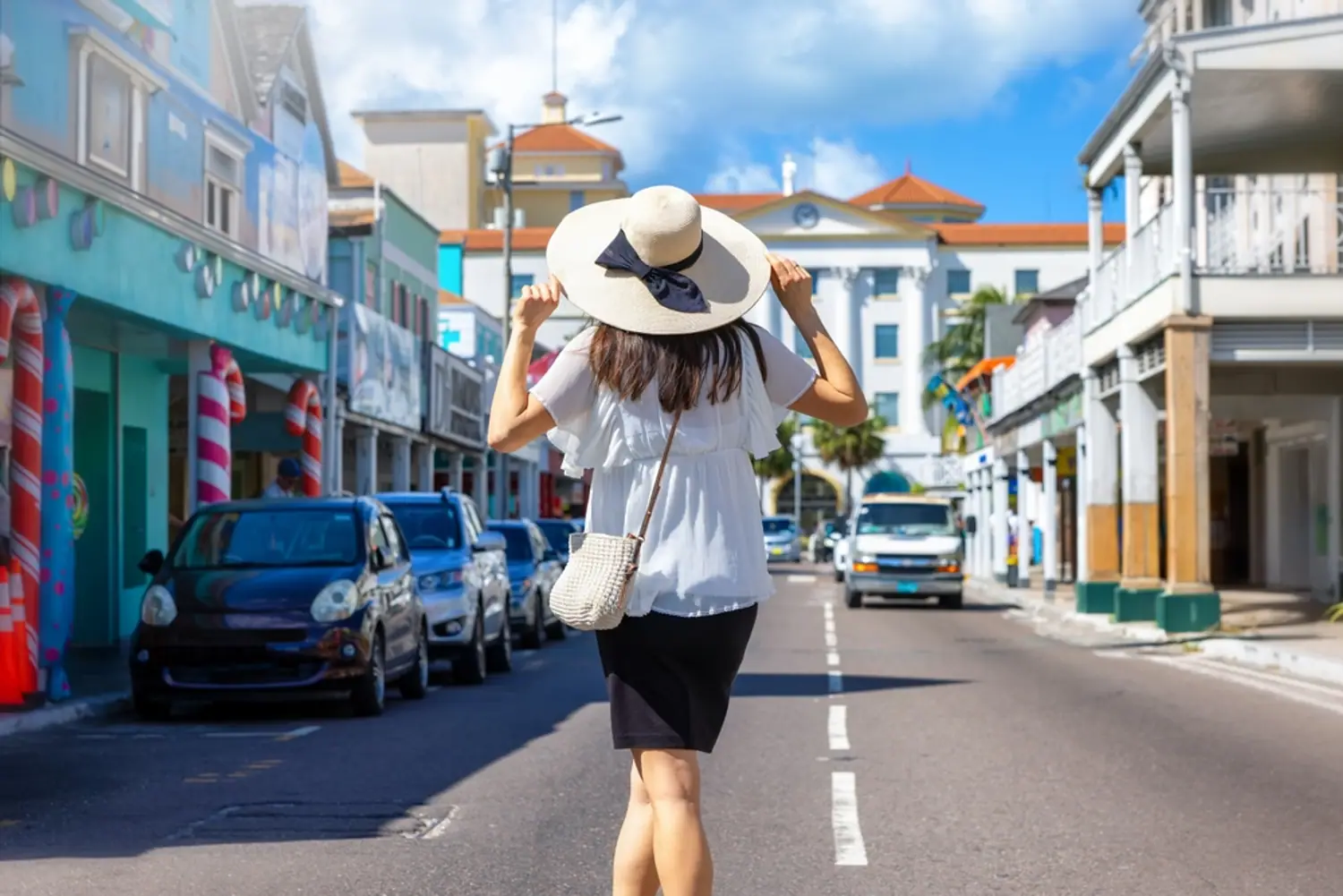 Cruise visitors walking a sunny, colorful street near the Nassau cruise port