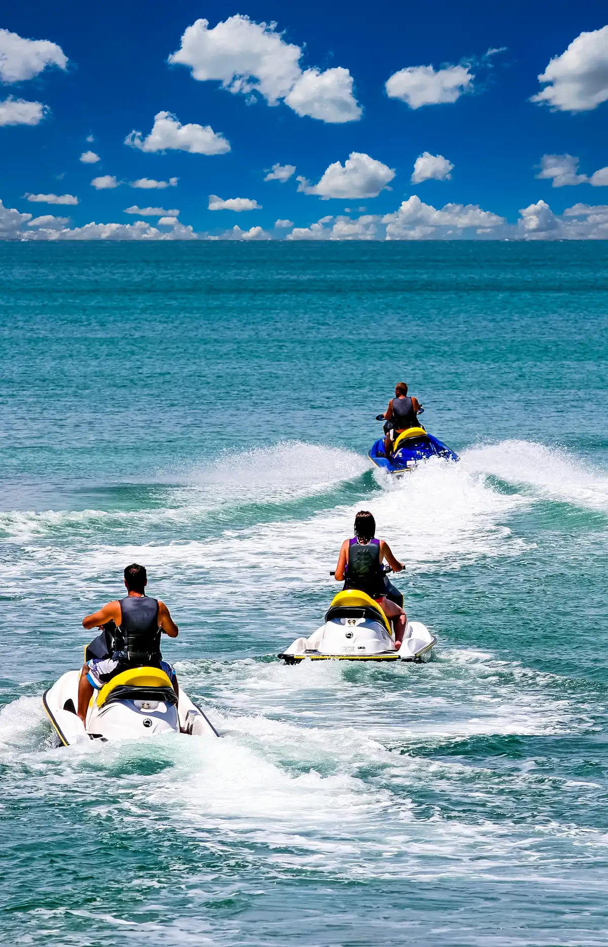 Visitors riding jet skis on calm turquoise water in Nassau